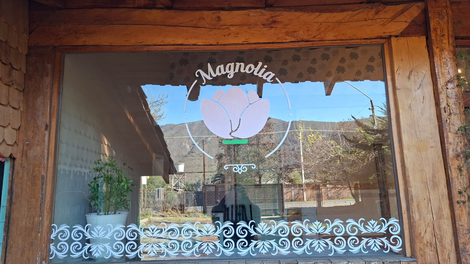 Logo de Magnolia grabado en el vidrio de la entrada