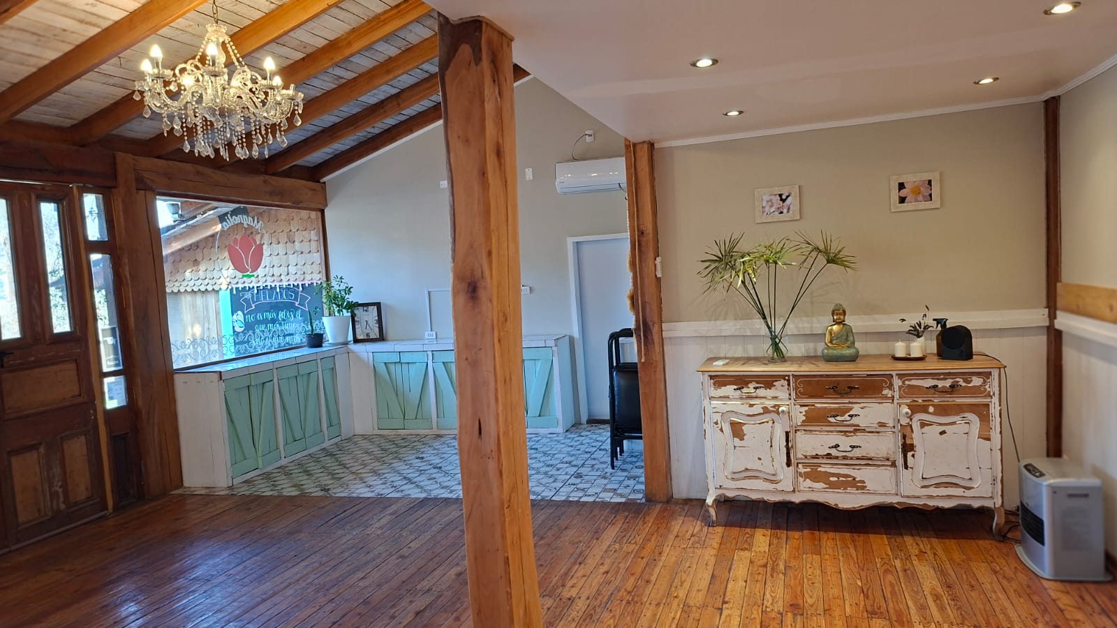 Salón con aparador antiguo, araña de cristal y detalles decorativos